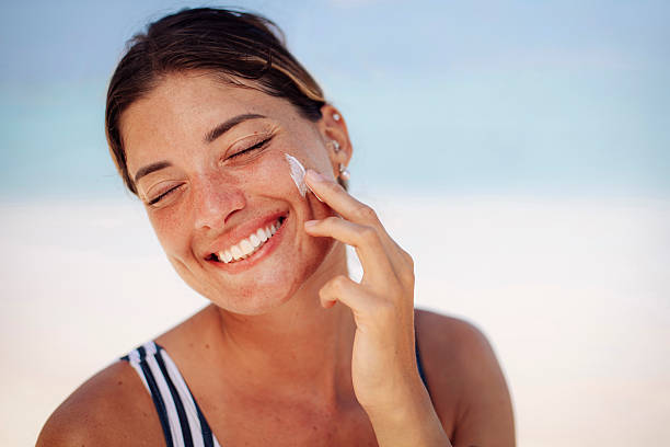 seorang wanita muda menggunakan sunscreen wajah