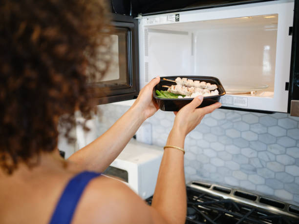 seseoraang memasukkan makanan ke dalam microwave