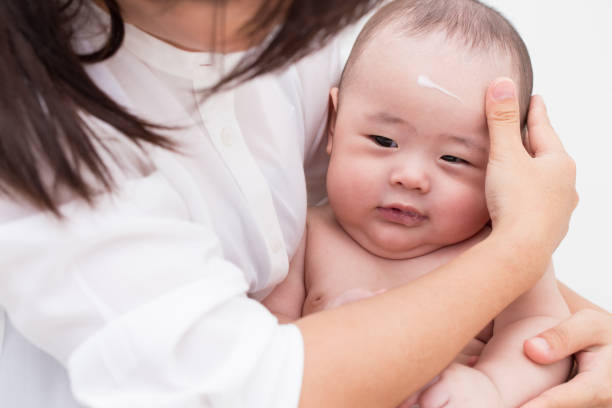 Ilustrasi ibu mengoleskan cream baby ke wajah bayi. Foto: champja/istockphoto