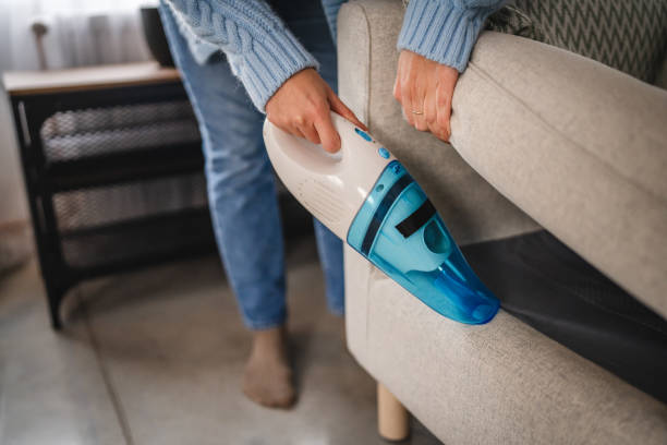 membersihkan celah dan sudut sofa menggunakan vacuum cleaner handheld
