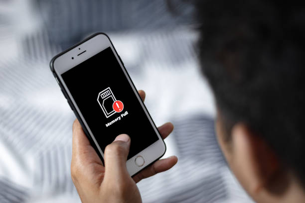 seseorang memegang smartphone dengan peringatan kartu memori penuh