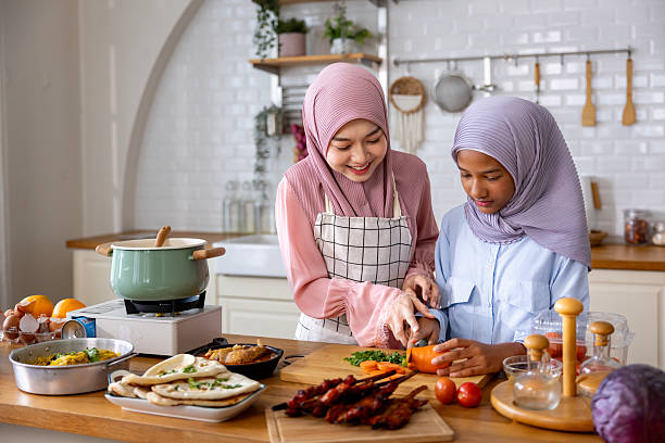 seorang ibu sedang mengajarkan masak kepada anaknya untuk membuat hidangan buka puasa