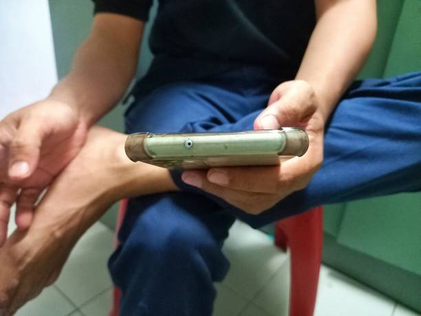 seseorang memegang hp dengan casing yang sudah menguning