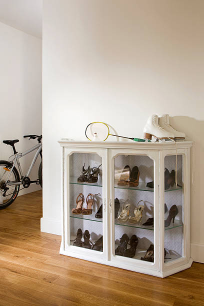 lemari rak sepatu tertutup warna putih terbuat dari material kayu dan kaca