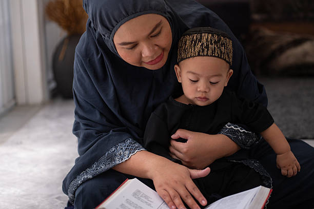 seorang ibu sedang mengajarkan Al-Qur’an kepada anaknya
