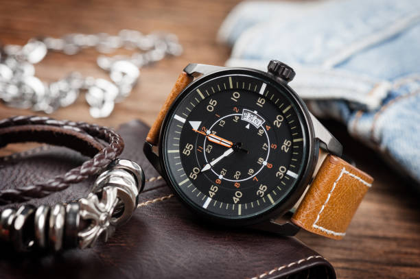 jam tangan pria, gelang pria, dan dompet pria di atas meja kayu
