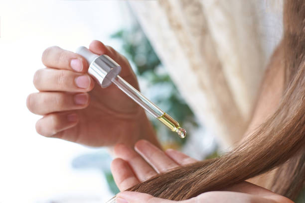 seseorang sedang menggunakan hair serum