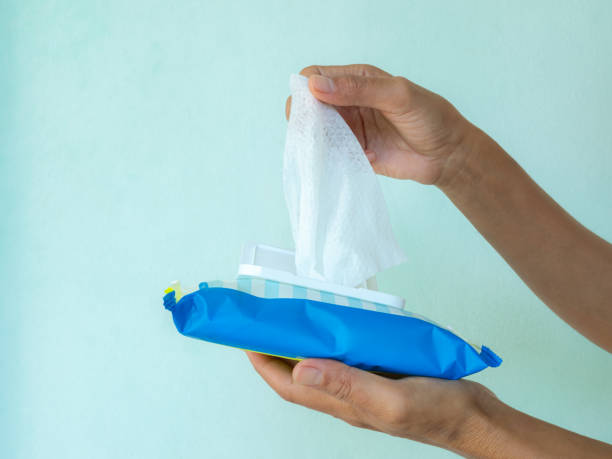 seseorang menarik tisu basah antiseptik dari kemasan