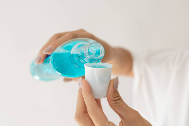 seseorang menuang obat kumur