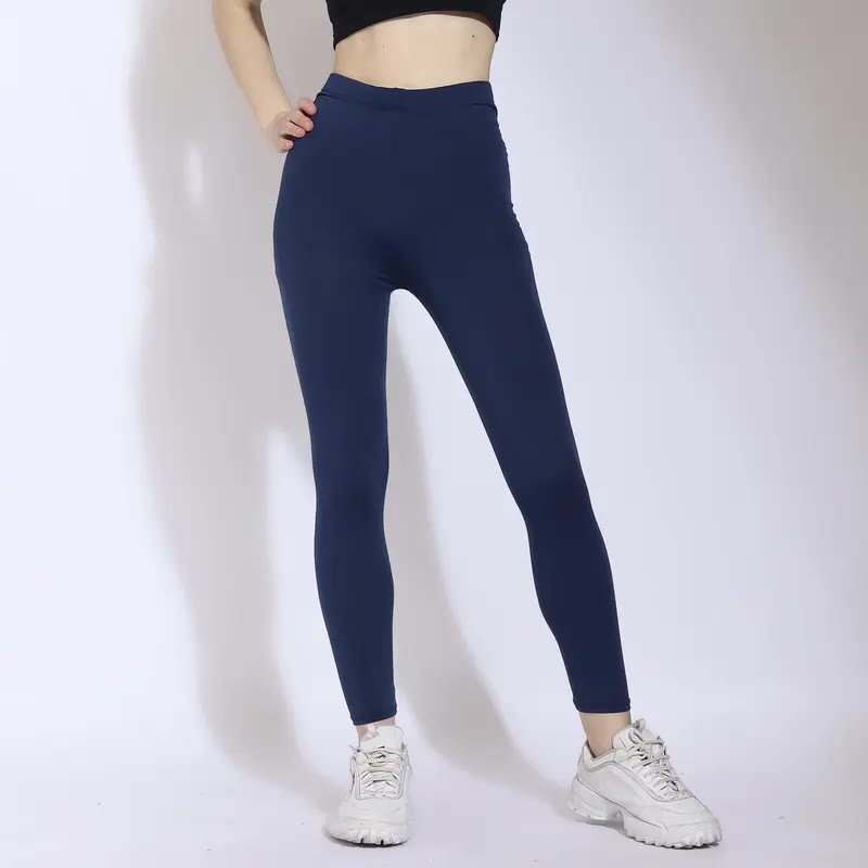 Legging olahraga navy high waist tampak dari pinggang sampai sepatu, menonjolkan potongan panjang dan ban pinggang yang rata