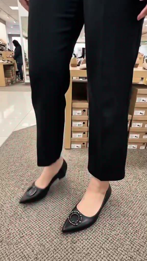 Close up flat shoes hitam berbuckle kristal dipakai dengan celana bahan hitam