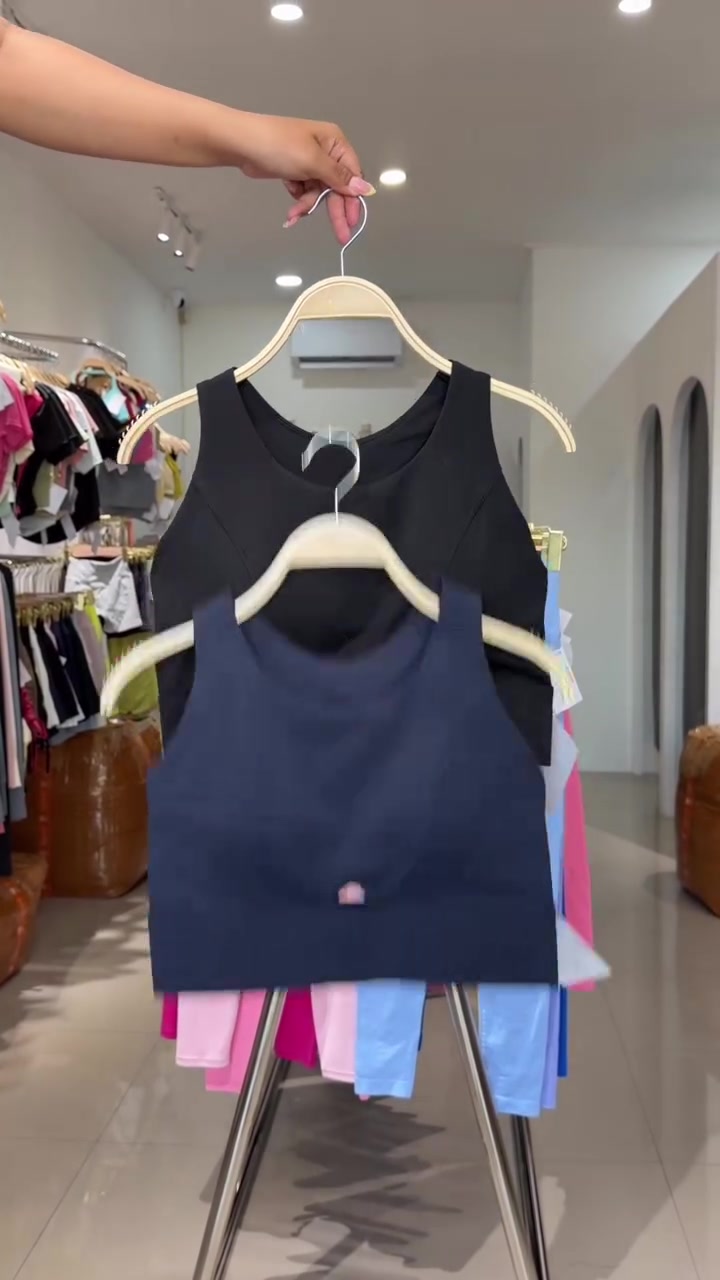Sport bra navy dan hitam tergantung di hanger dengan tag ukuran
