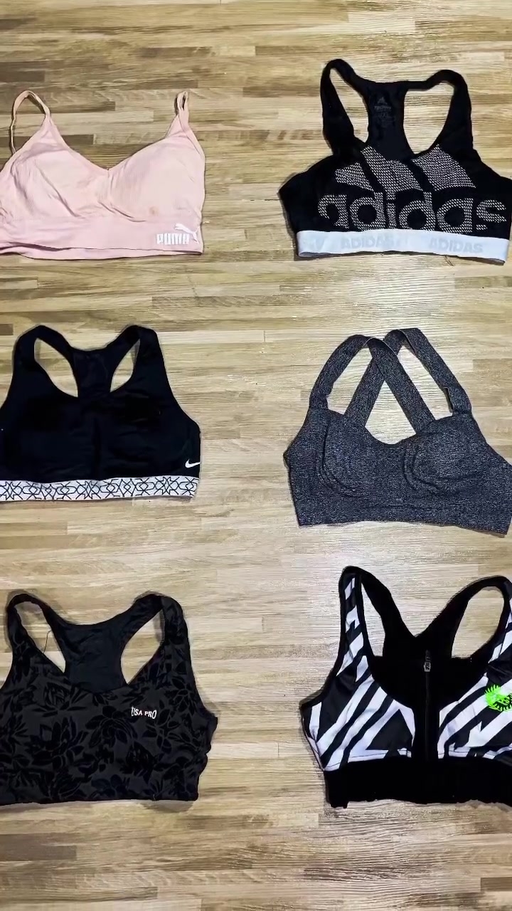 Enam sport bra berbagai warna dan model strap terbentang rata di lantai kayu