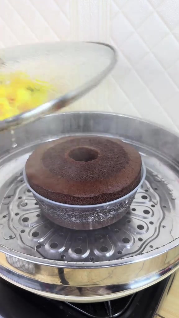 Bolu kukus cokelat yang sudah mengembang sempurna di dalam kukusan aluminium bersaringan lubang