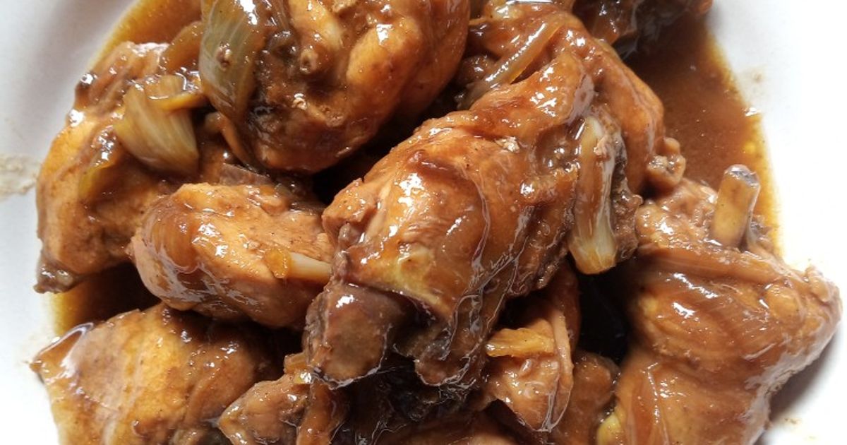 Potongan ayam masak kecap berwarna cokelat mengilap tersusun rapat di piring putih