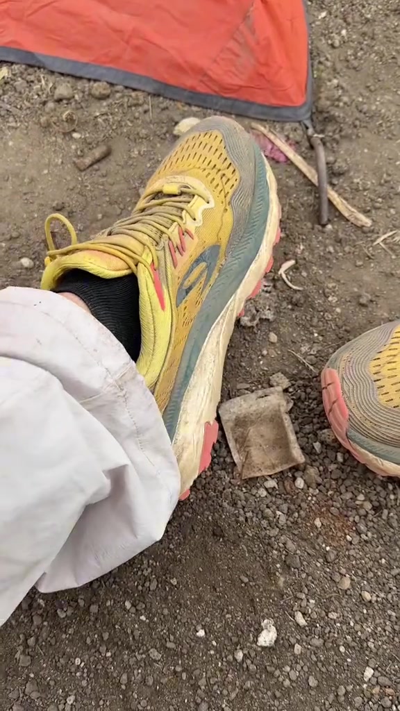 Sepatu trail 910 seri Yuza warna kuning menapak di jalur kerikil vulkanik
