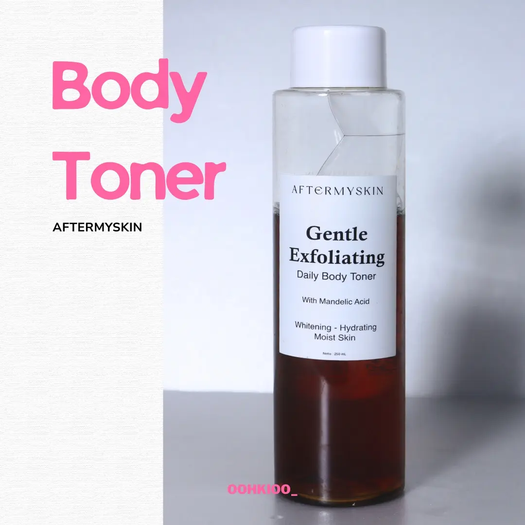 Botol bening Aftermyskin Gentle Exfoliating Daily Body Toner berisi cairan cokelat kemerahan dengan label putih