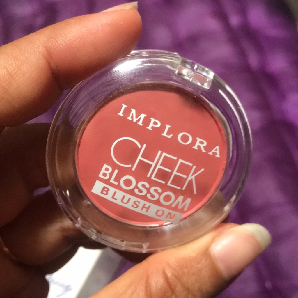 Compact Implora Cheek Blossom Blush On dengan pan warna salmon dipegang tangan