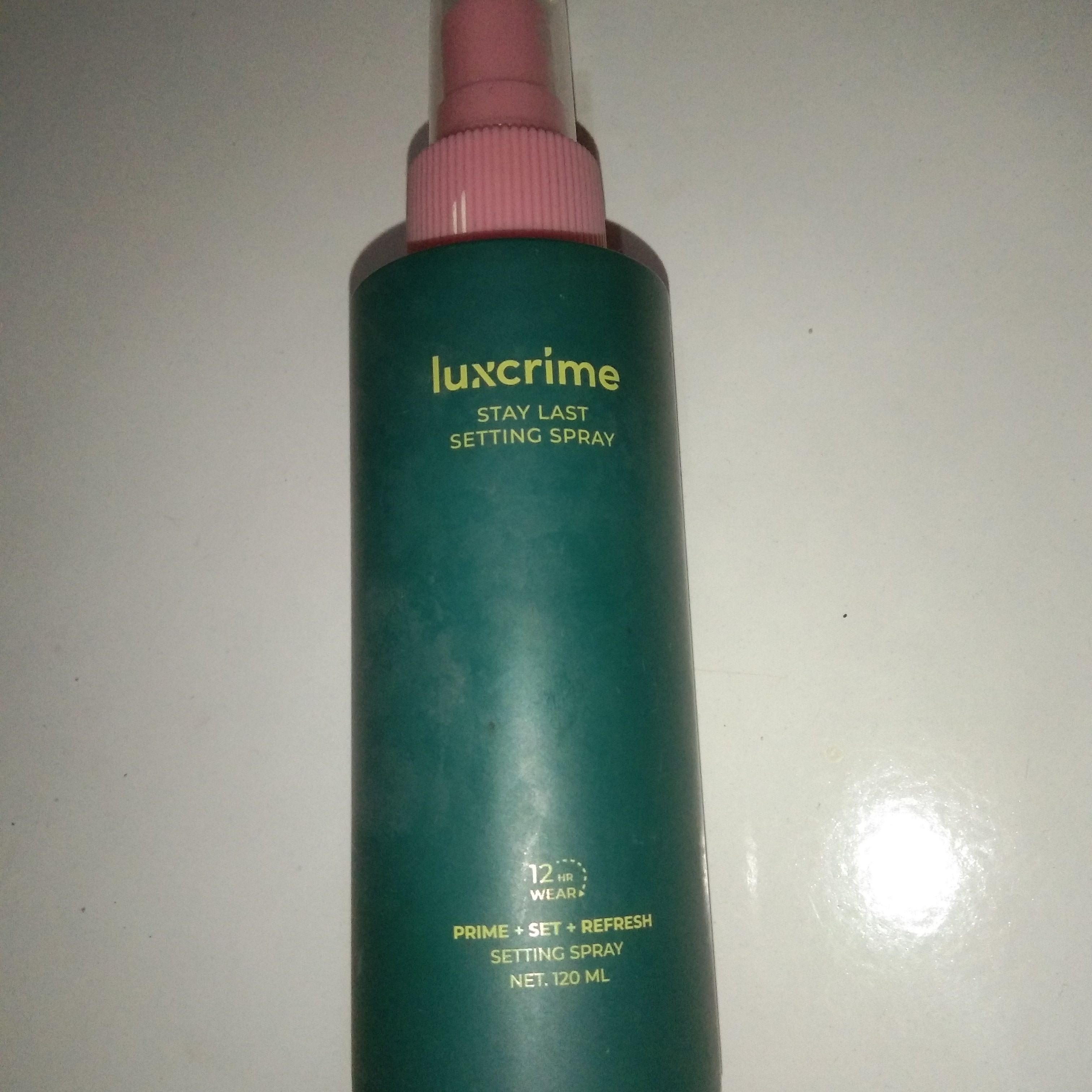 Botol hijau Luxcrime Stay Last setting spray 120 ml dengan tutup spray merah muda