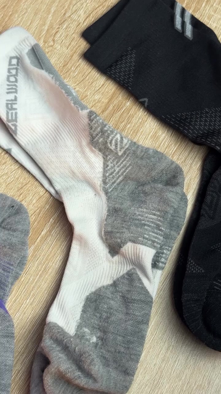 Kaos kaki lari merino putih abu dan hitam dibentangkan di meja kayu memperlihatkan perbedaan rajutan tiap zona