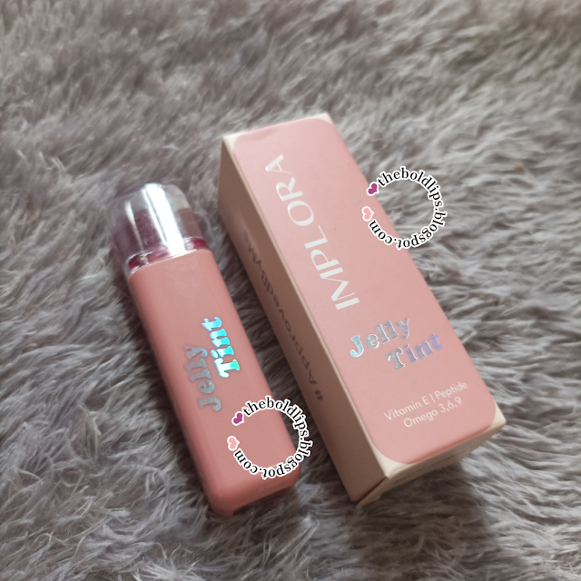 Tube Implora Jelly Tint warna peach beserta kotaknya yang mencantumkan vitamin E, peptide, dan omega 3.6.9