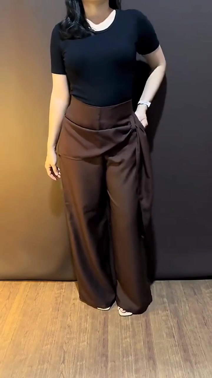Celana palazzo coklat dengan detail ikat wrap tie di pinggang dipadukan atasan hitam, tampak dari leher ke bawah