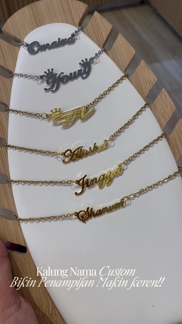 Enam kalung nama custom warna silver dan gold tersusun rapi di display stand