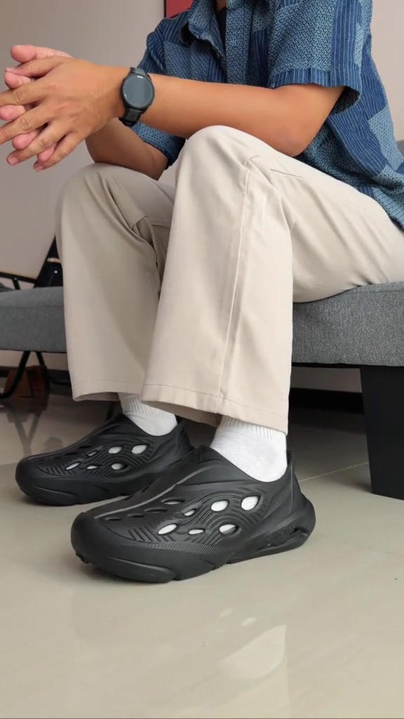 Porto X Kyro warna hitam dipakai dengan kaos kaki putih saat duduk di sofa abu-abu