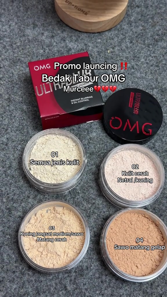 Empat jar OMG Ultrablur Loose Powder terbuka menampilkan shade 01 sampai 04 beserta box merah dan tutup hitam di atas kain abu-abu