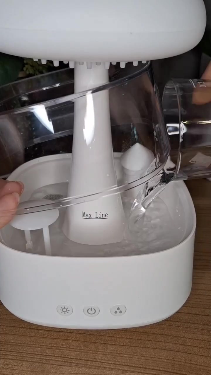 Tangan menuang air dari gelas takar ke tangki diffuser ultrasonik hingga batas garis maksimum