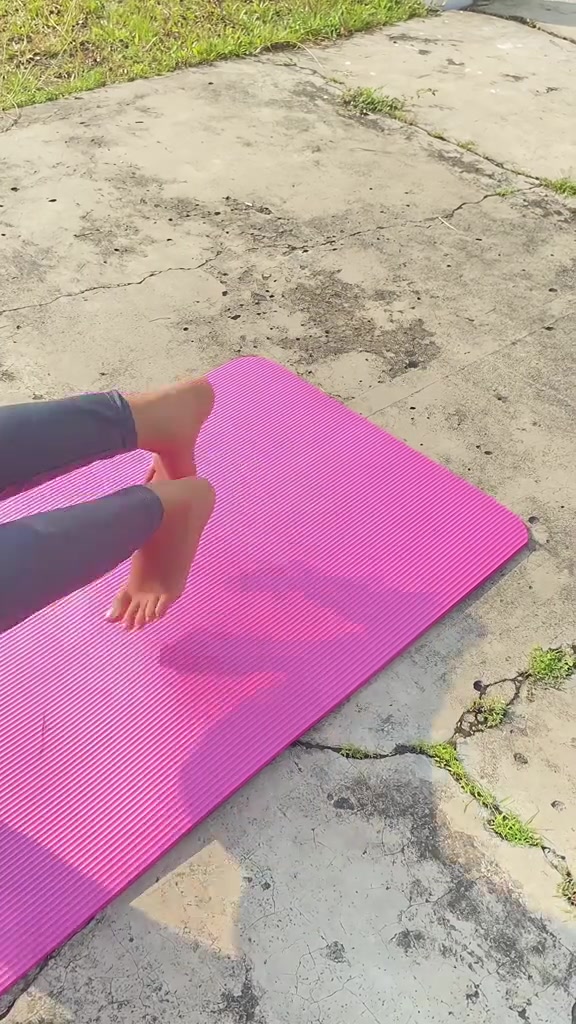 Kaki bertumpu di matras magenta beralur rib yang digelar di luar ruangan