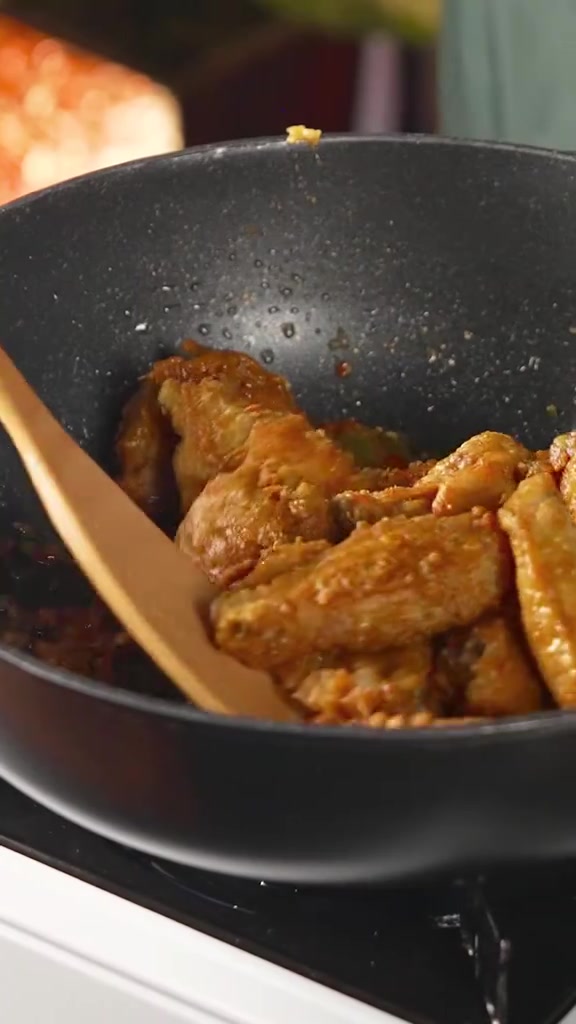 Sayap ayam goreng bertemu sambal chili padi di dalam wajan hitam dengan spatula kayu