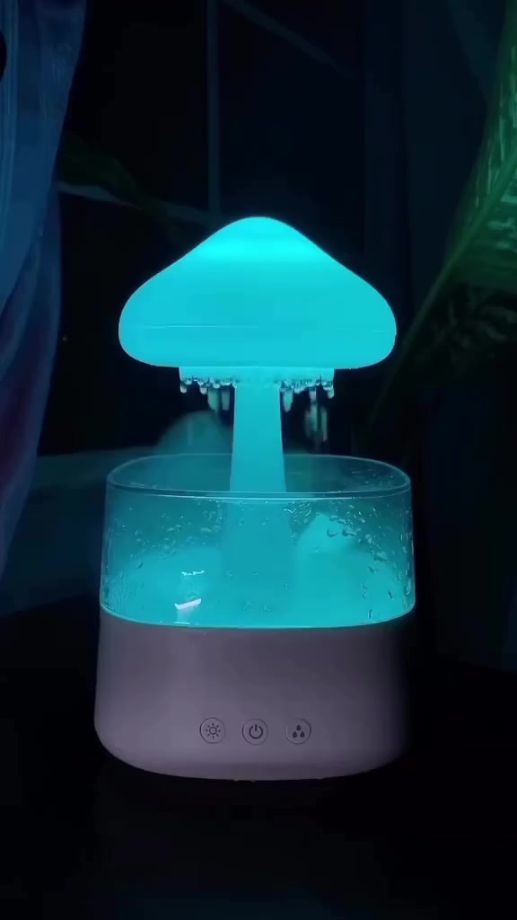 Diffuser ultrasonik menyala biru di ruangan gelap dengan kabut halus keluar dari bagian atasnya