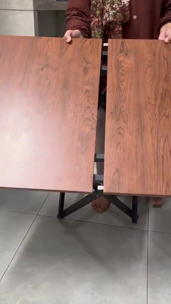 Meja lipat portable permukaan kayu dengan kaki besi hitam sedang dibuka setengah