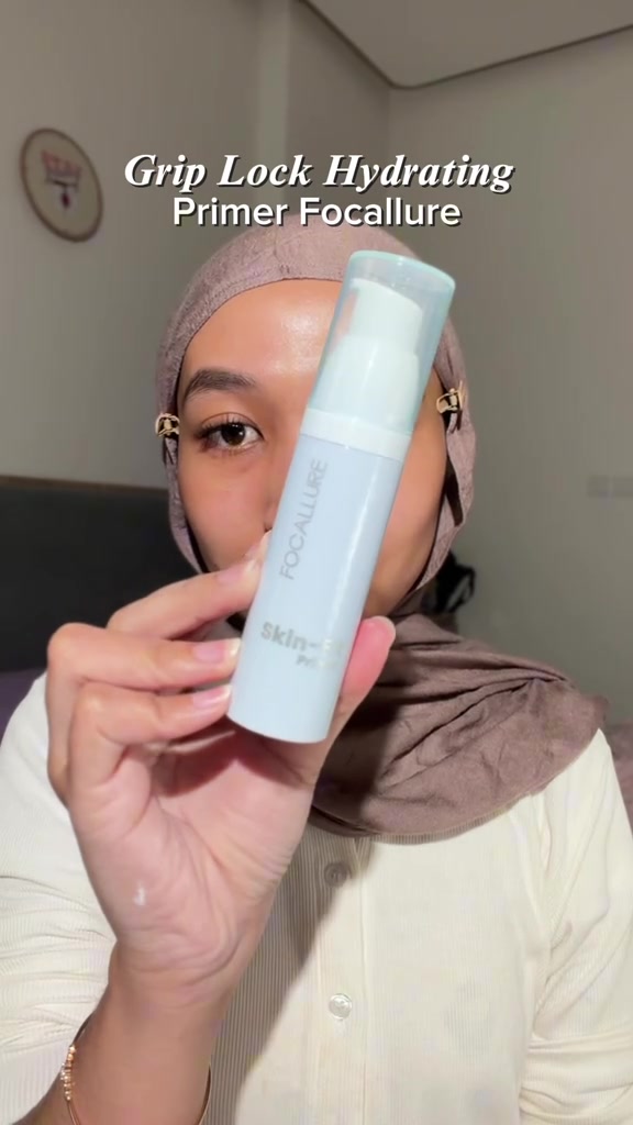 Botol Focallure Grip Lock Hydrating Primer dipegang di depan kamera dengan tulisan Focallure skin-fit terbaca pada badan botol