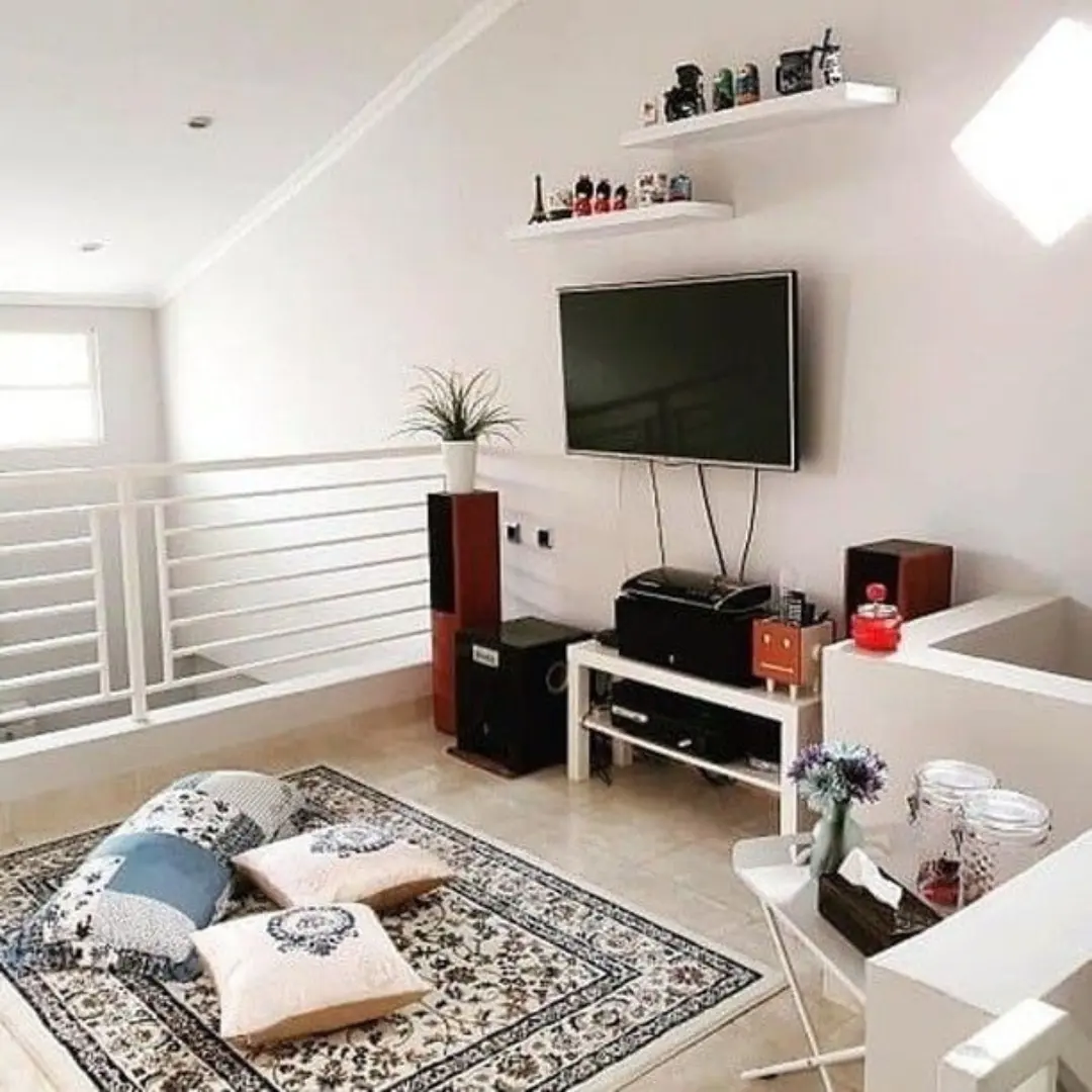 Area lesehan di lantai atas dengan karpet permadani bermotif dan bantal duduk sebagai tempat duduk
