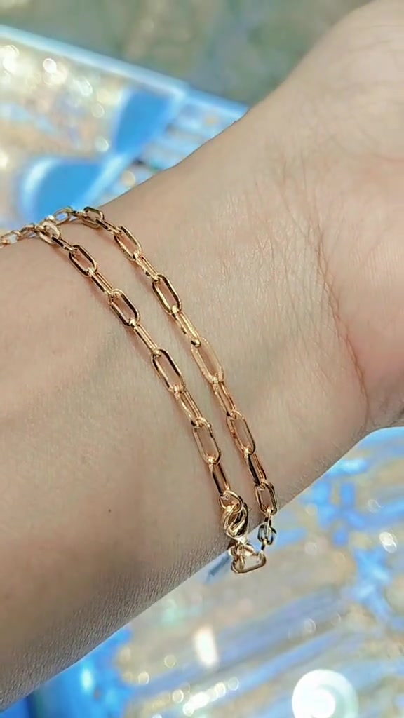 Rantai paperclip warna rose gold dililitkan dua kali di pergelangan tangan