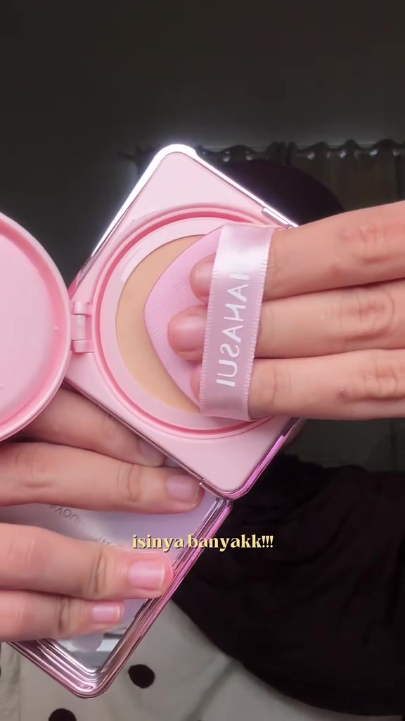 Kompak cushion pink Hanasui terbuka dilihat dari atas, puff bertali ditekan ke bagian mesh untuk mengambil produk