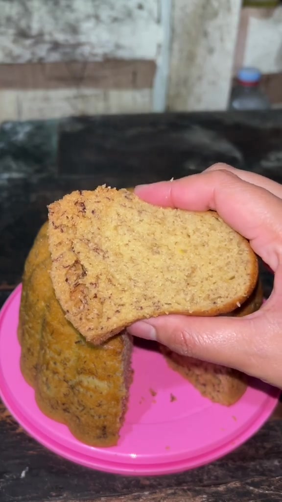 Potongan bolu pisang dipegang tangan memperlihatkan serat yang lembut