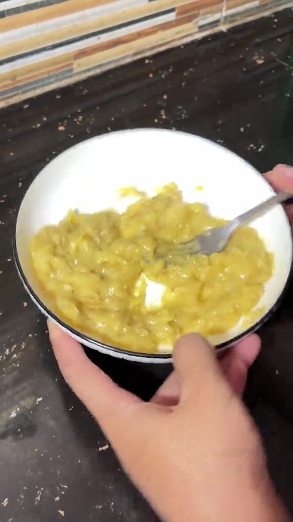 Pisang matang yang sudah dilumat dengan garpu di mangkuk putih