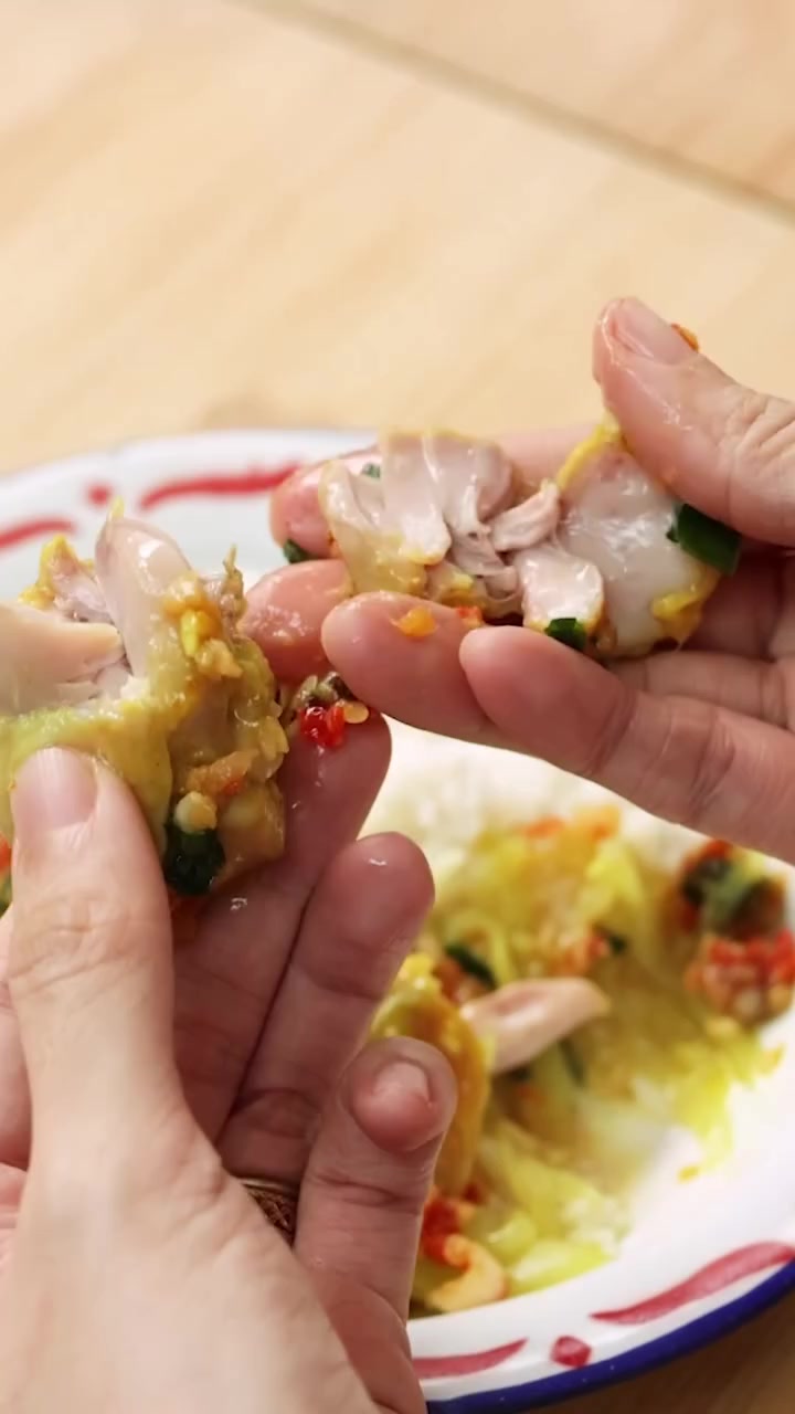 Daging ayam kukus disobek dengan tangan menunjukkan serat lembut dengan bumbu cabai dan bawang yang meresap