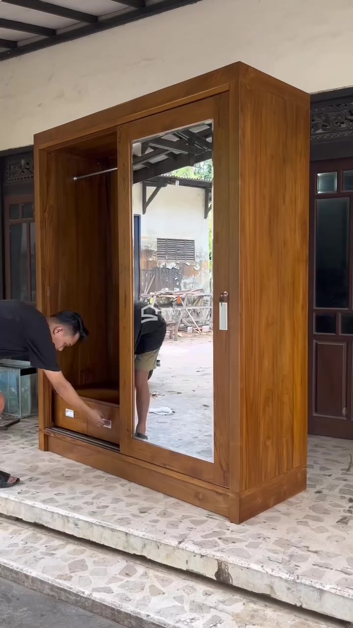 Lemari kayu jati pintu sliding dengan cermin sedang diperiksa pengrajin di teras workshop