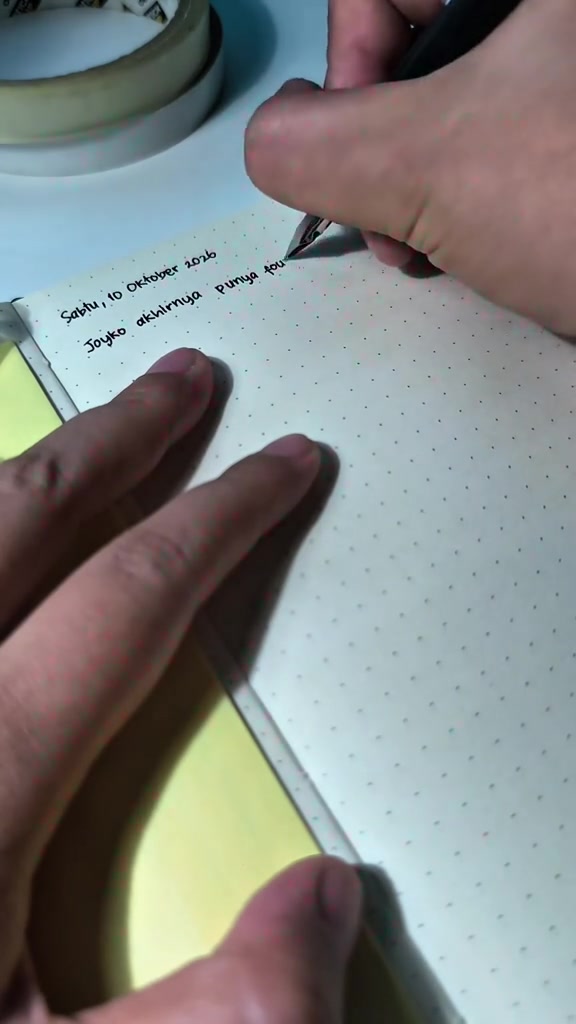 Joyko fountain pen hitam dipakai menulis catatan di notebook bertitik