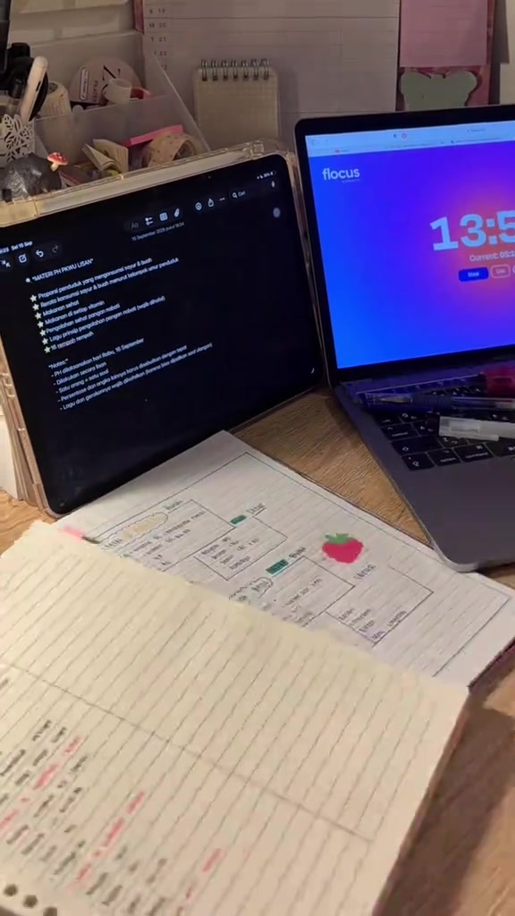 Meja belajar dengan rangkuman bertanda warna dan timer di layar