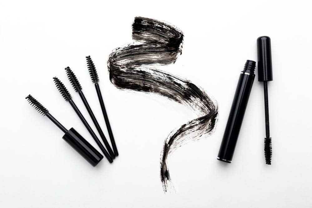 Aplikator spoolie hitam dan coretan tekstur gel browcara di atas latar putih