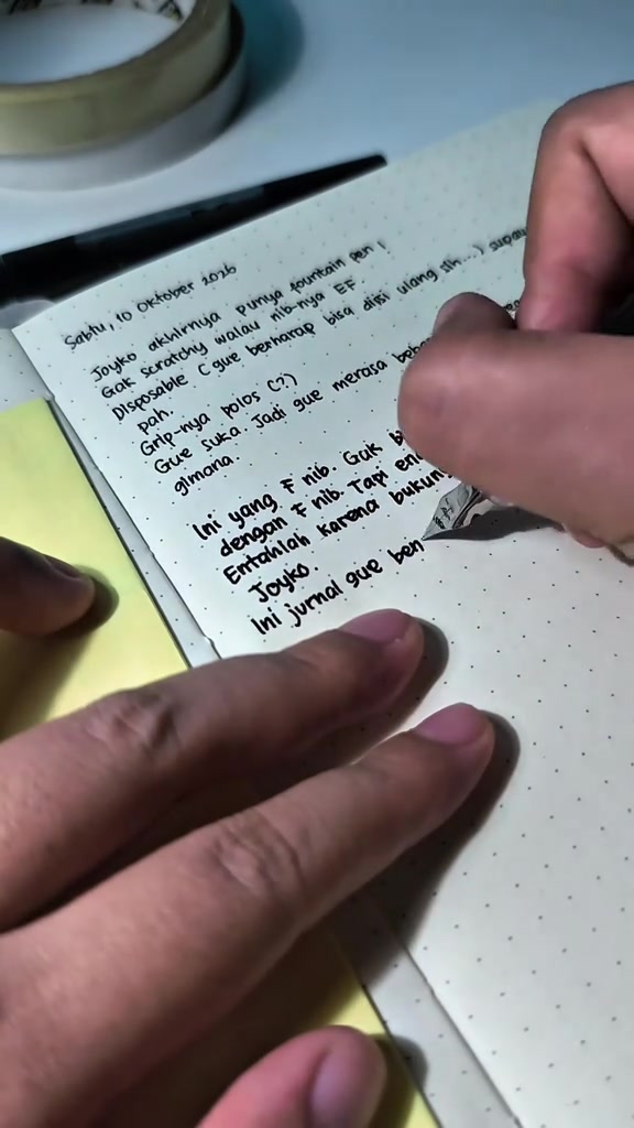 Pulpen fountain pen menulis catatan tangan pada kertas notebook bertitik