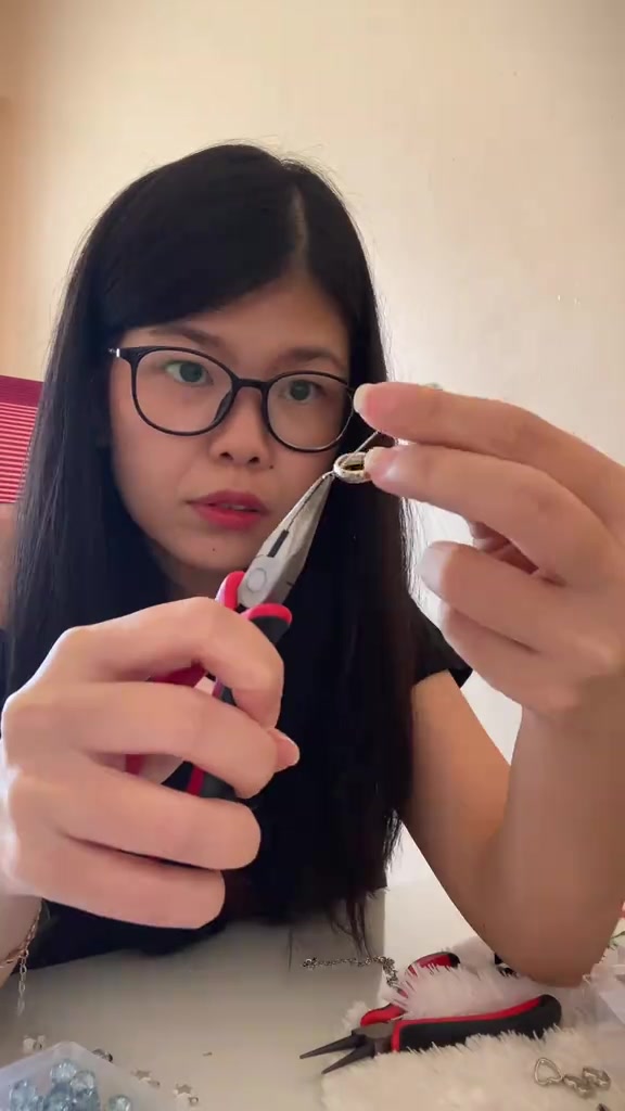 Tangan memegang bagian kecil pengait kacamata di dekat frame