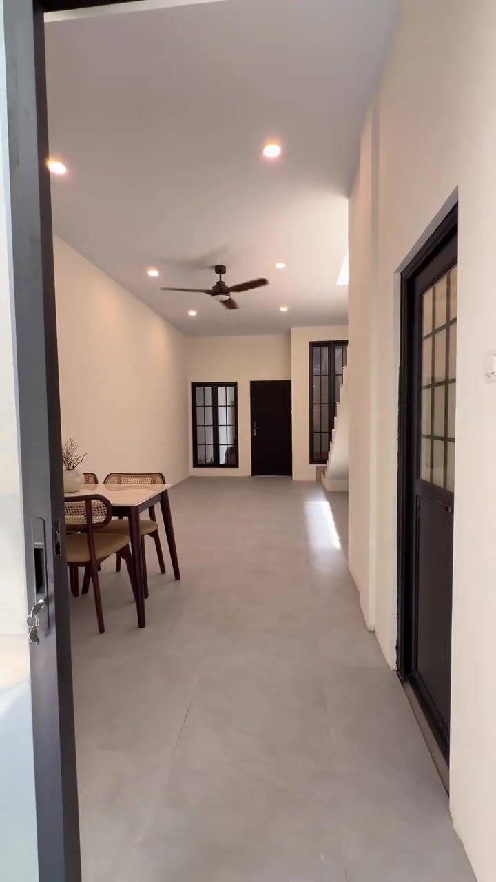 Ruang makan dan ruang keluarga dengan kipas plafon di tengah langit-langit