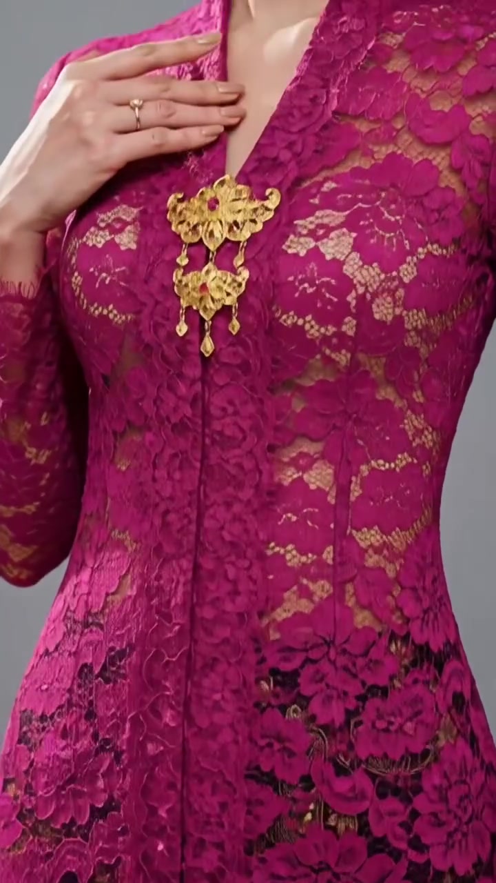 Detail kebaya lace fuchsia potongan fitted dengan leher V dan bros emas di dada