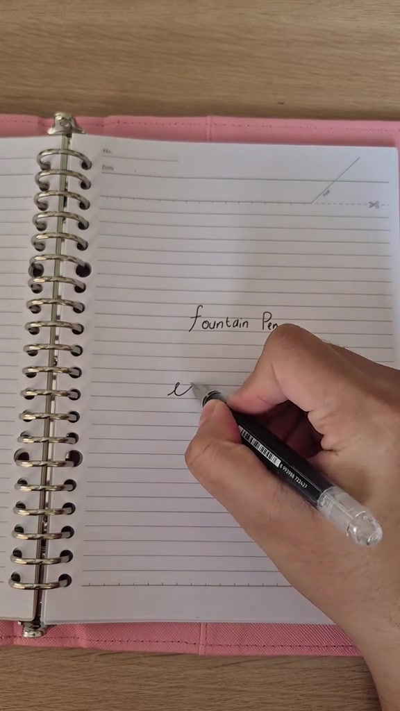 Tangan menguji goresan Joyko fountain pen pada halaman notebook